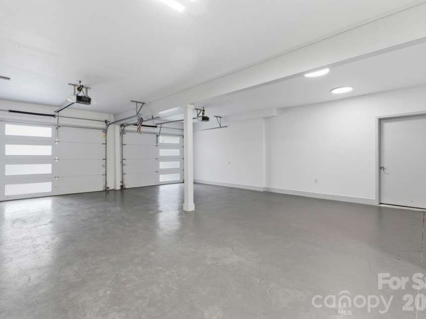 22 Lara Drive, Mills River, NC 28759.  MLS# CAR4382358, YatesRealty ID 23687. Oversized multi-car garage with high ceilings, ample storage space, and modern insulated garage doors.