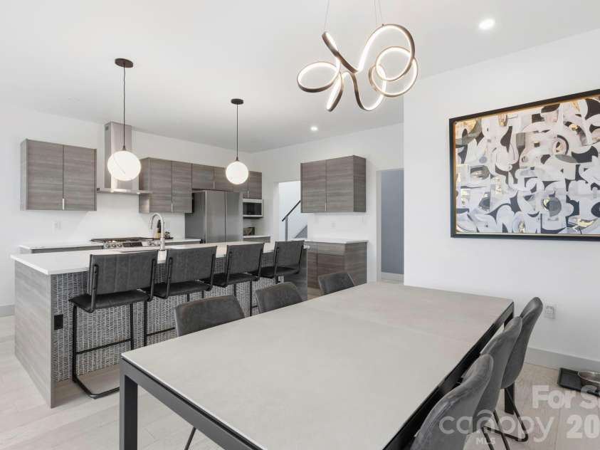 22 Lara Drive, Mills River, NC 28759.  MLS# CAR4382358, YatesRealty ID 23687. Spacious dining room overlooking the modern kitchen with oversized island seating, sleek finishes, and designer fixtures throughout.
