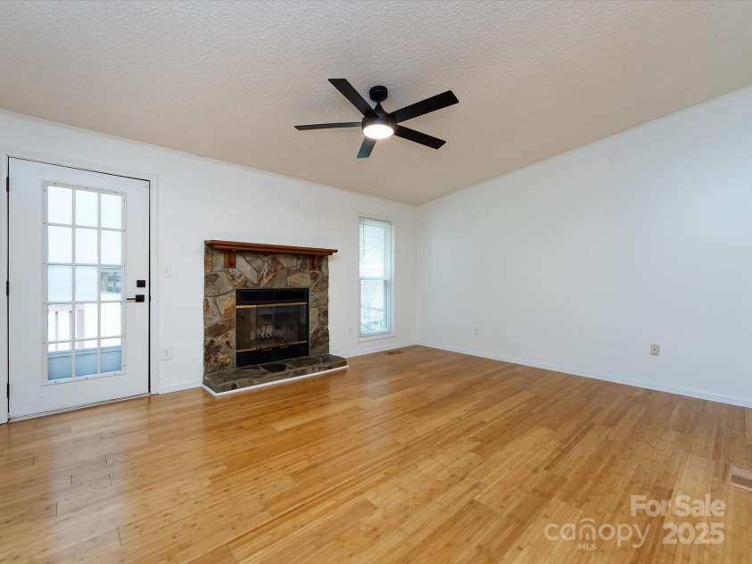 7960 Tiburon Circle, Charlotte, NC 28215.  MLS# CAR4276761, YatesRealty ID 23690. Family room with wood burning fireplace that has a stone facade.