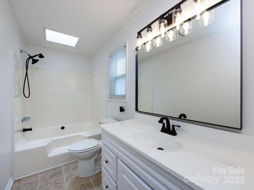 7960 Tiburon Circle, Charlotte, NC 28215.  MLS# CAR4276761, YatesRealty ID 23690. Primary bathroom with updated mirrors, lighting, and large soaking tub.