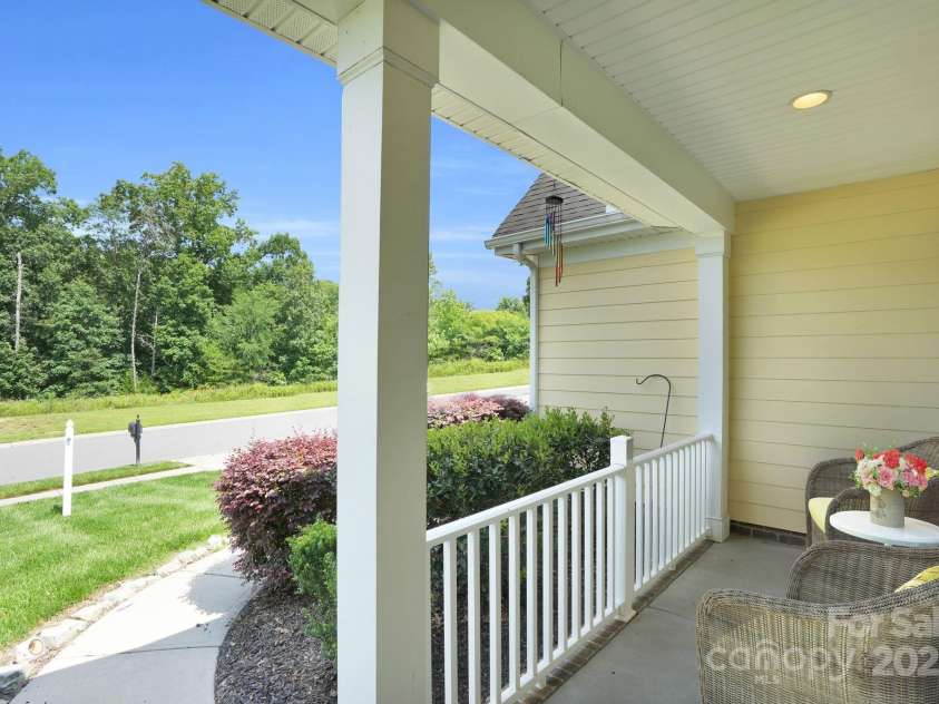 11618 Macallano Drive, Charlotte, NC 28215.  MLS# CAR4268252, YatesRealty ID 23742. Rocking chair front porch looks out to wooded common area