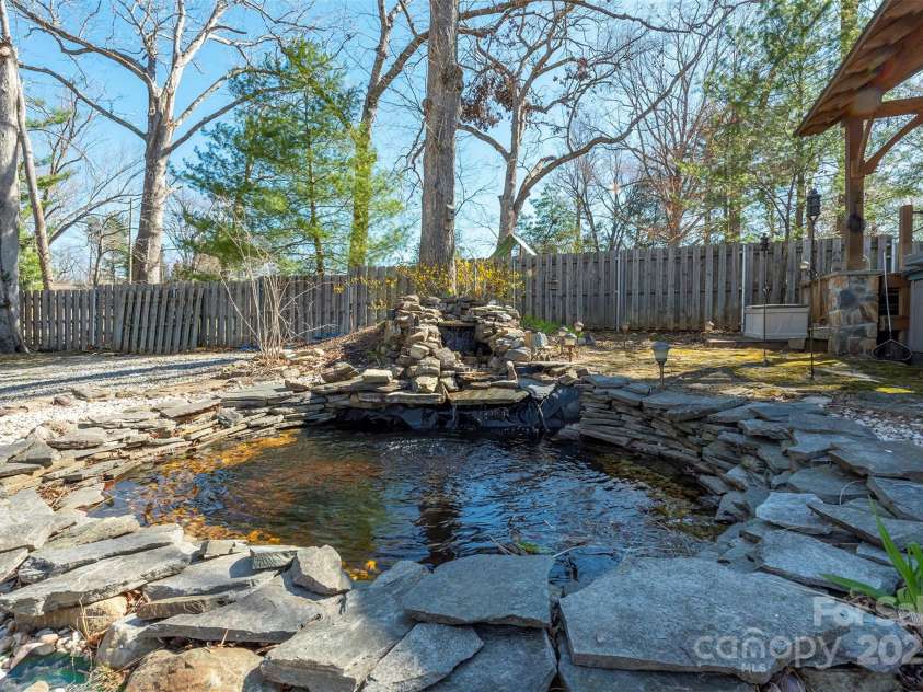 1740 Haywood Road, Hendersonville, NC 28791.  MLS# CAR4226897, YatesRealty ID 2378. Enjoy the tranquility of a beautiful waterfall and pond, adding a serene touch to your outdoor space.