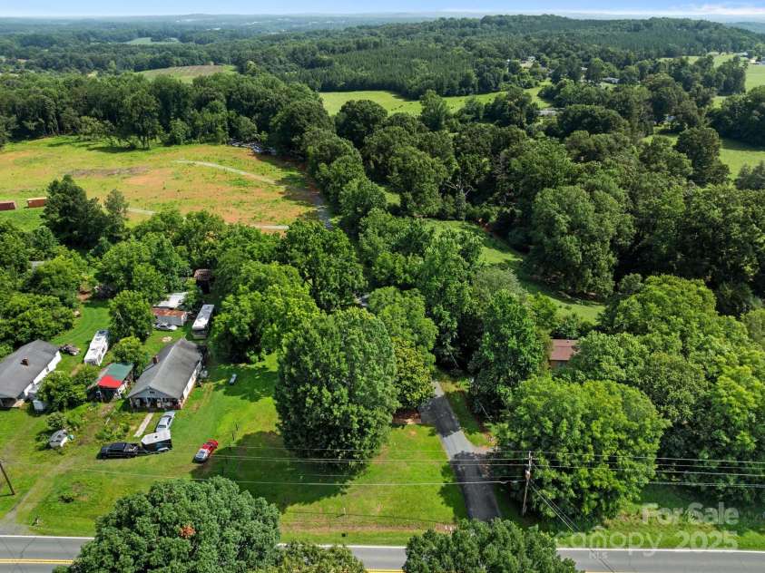 28419 NC Hwy 73 Highway, Albemarle, NC 28001.  MLS# CAR4226158, YatesRealty ID 23808. From front, Home is shaded under the trees.