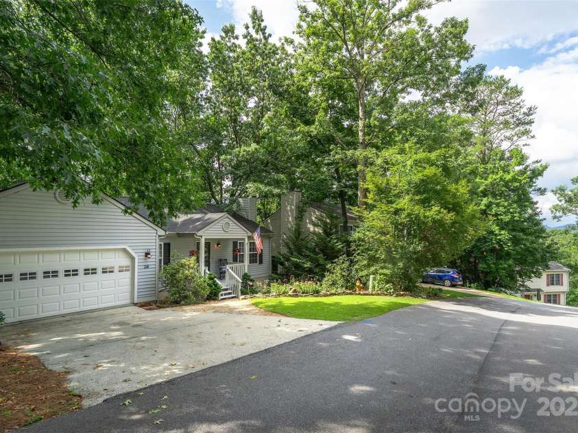 26 Foxberry Drive, Arden, NC 28704.  MLS# CAR4325945, YatesRealty ID 2381. Front of home in wooded neighborhood with mountain views from the street. 
