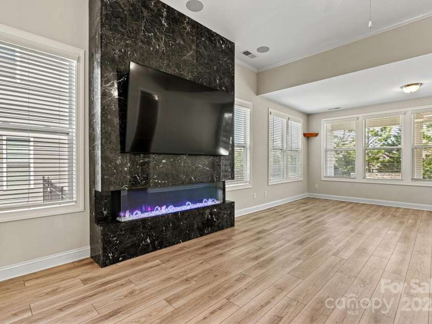 7315 Surprise Court, Charlotte, NC 28215.  MLS# CAR4276101, YatesRealty ID 23823. Extended living area centers around a showstopping floor-to-ceiling electric fireplace with mounted flat screen TV that conveys with the home.