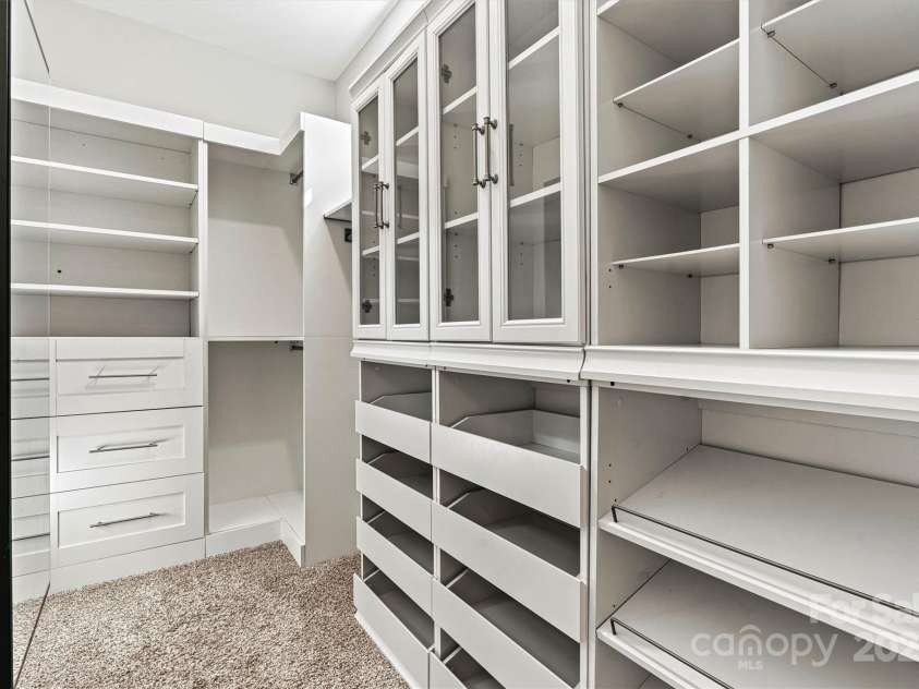 7315 Surprise Court, Charlotte, NC 28215.  MLS# CAR4276101, YatesRealty ID 23823. Largest Primary bedroom closet features ClosetMaid shelving and a mirrored shoe storage wall cabinet.