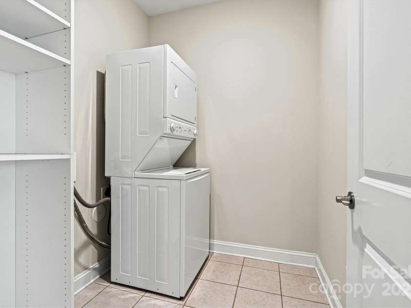 7315 Surprise Court, Charlotte, NC 28215.  MLS# CAR4276101, YatesRealty ID 23823. Laundry room features a stackable washer/dryer (included) to maximize space, plus a white shelving unit that conveys—combining space-saving design with everyday function.