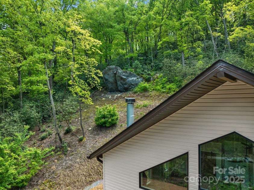 143 Burnside Trail, Hendersonville, NC 28792.  MLS# CAR4258291, YatesRealty ID 23895. 4+acre property features large rock outcropping above the house.