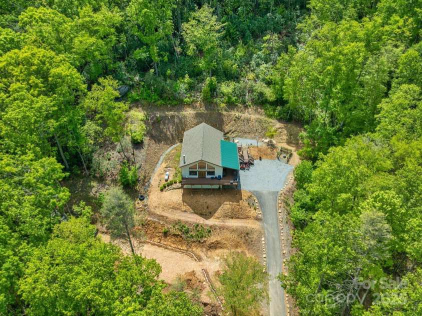 143 Burnside Trail, Hendersonville, NC 28792.  MLS# CAR4258291, YatesRealty ID 23895. Aerial of property: notice how owners have cleared trees and built paths around the house.