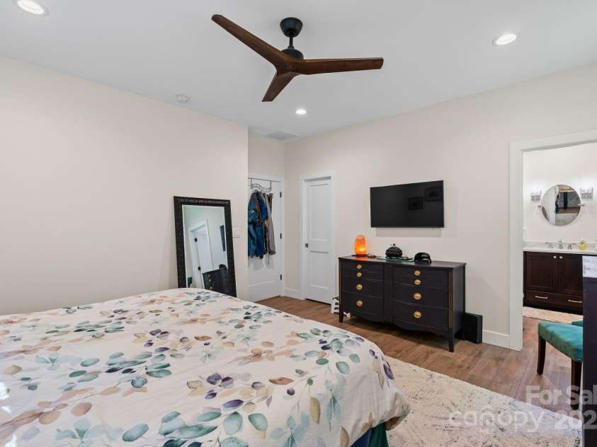 143 Burnside Trail, Hendersonville, NC 28792.  MLS# CAR4258291, YatesRealty ID 23895. Main-level primary bedroom with walk-in closet.