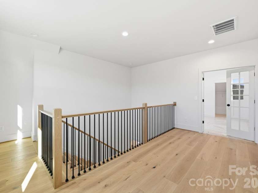 7245 Westrow Avenue, Charlotte, NC 28278.  MLS# CAR4314661, YatesRealty ID 2395. Generous upper hallway featuring hardwood flooring and an open railing that enhances the sense of space and light. A seamless flow between upstairs living areas. 