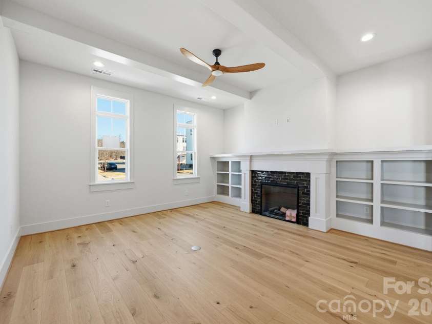 7245 Westrow Avenue, Charlotte, NC 28278.  MLS# CAR4314661, YatesRealty ID 2395. Inviting family room showcasing a fireplace flanked by custom built-ins. Ceiling beams and warm hardwood floors make this space perfect for entertaining or everyday living.