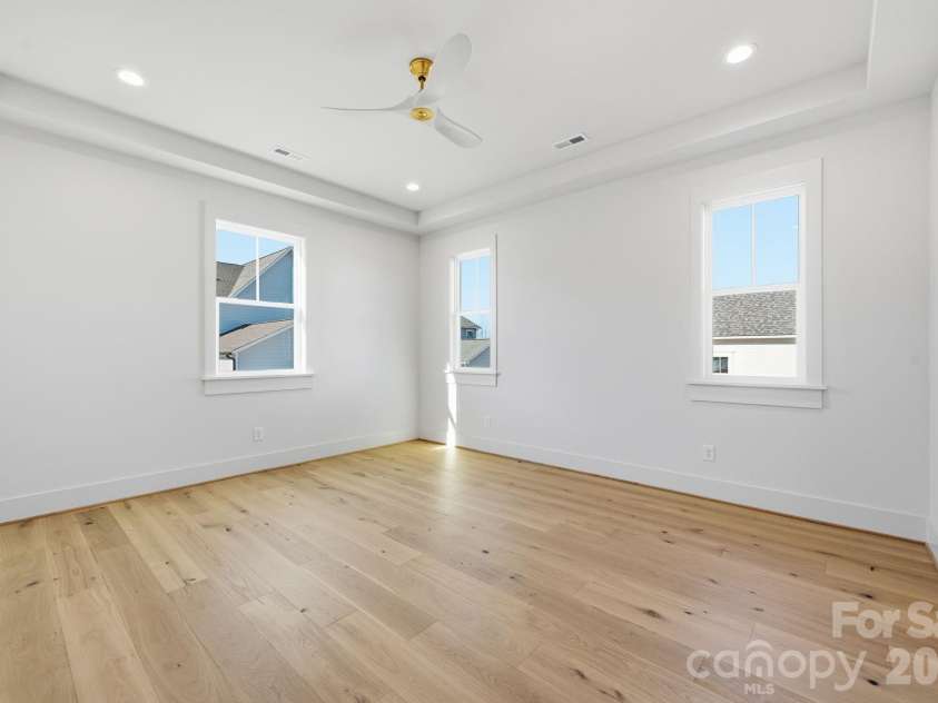 7245 Westrow Avenue, Charlotte, NC 28278.  MLS# CAR4314661, YatesRealty ID 2395. Spacious primary suite on the lower level with tray ceiling. Added recessed lighting and windows fill the room with natural light. A perfect space to unwind at the end of the day.