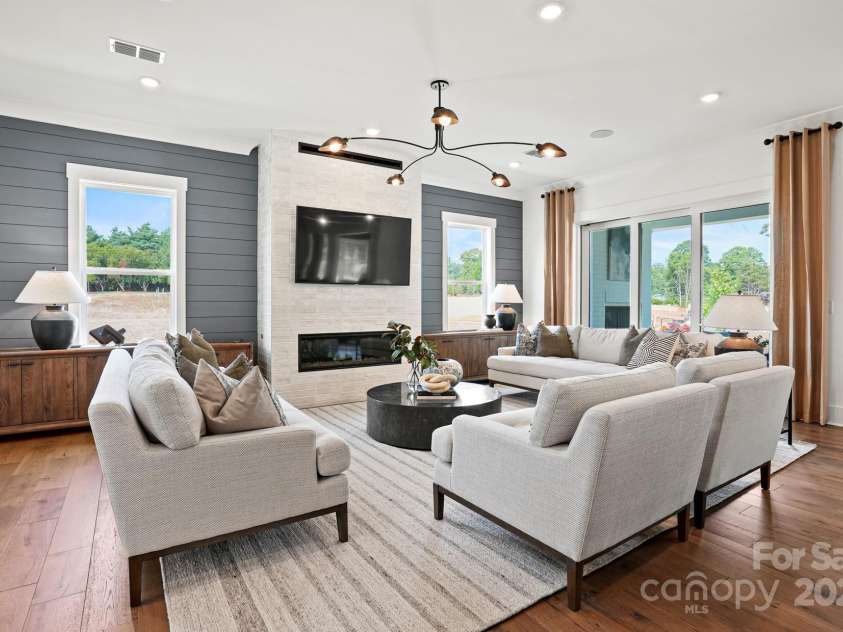 14011 Camden Close Circle, Huntersville, NC 28078.  MLS# CAR4271139, YatesRealty ID 23982. Spacious gathering room with tile fireplace and shiplap wall detail.  Triple sliding door leads out to covered back porch with exterior fireplace.