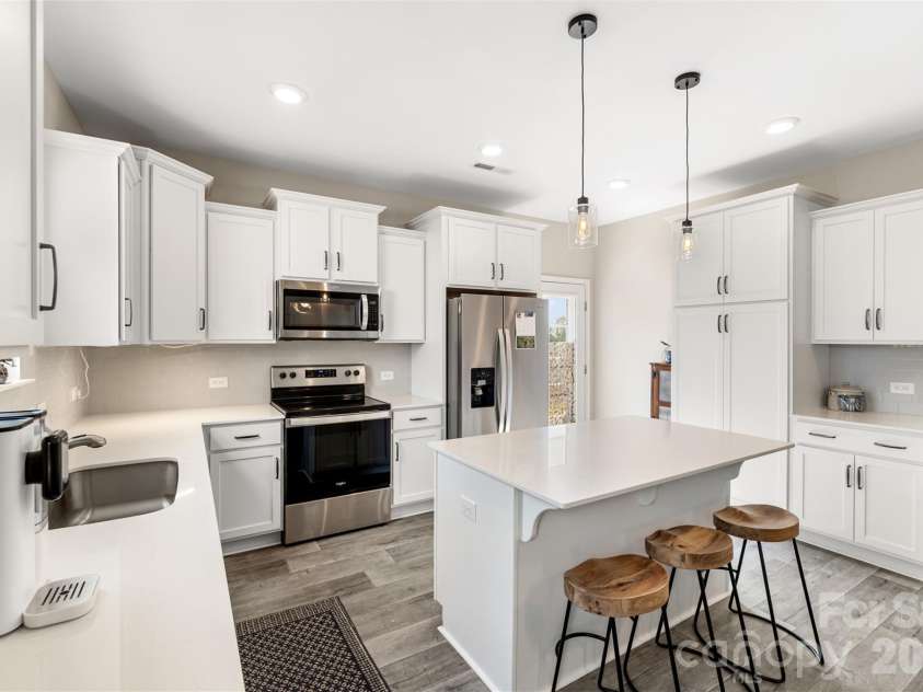 43 Cobbler Drive, Peachland, NC 28133.  MLS# CAR4377302, YatesRealty ID 23989. Stylish kitchen features quartz countertops, tile backsplash, stainless steel appliances, and ample cabinetry for storage.