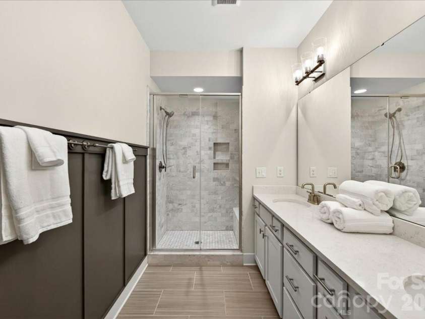 4136 Castleton Road, Charlotte, NC 28211.  MLS# CAR4381124, YatesRealty ID 24040. Primary ensuite bath with dual vanity, wainscoting, and large walk-in shower.
