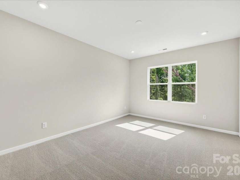 6049 Longar Lane, Charlotte, NC 28269.  MLS# CAR4384836, YatesRealty ID 24079. Primary bedroom with tree-lined views