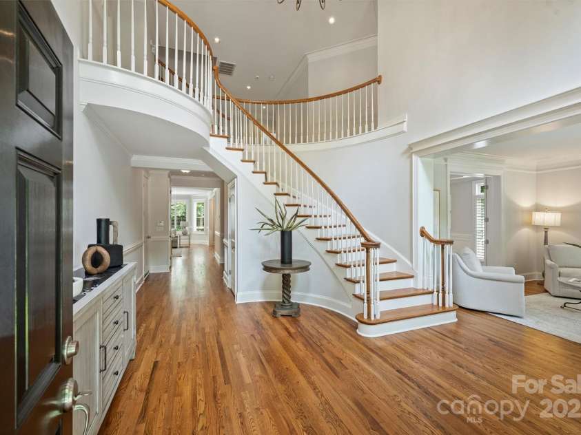7319 Stonehaven Drive, Waxhaw, NC 28173.  MLS# CAR4266937, YatesRealty ID 24083. The elegant 2-story foyer showcases the winding staircase; note the newly refinished hardwood floors.  The whole house was freshly painted in May, 2025.