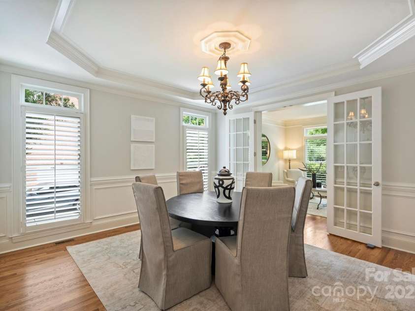 7319 Stonehaven Drive, Waxhaw, NC 28173.  MLS# CAR4266937, YatesRealty ID 24083. This inviting dining room features a tray ceiling, wainscoting and French doors to the living room area.