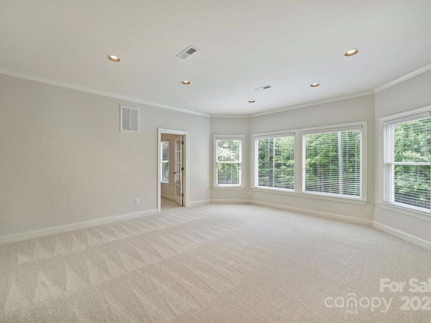 7319 Stonehaven Drive, Waxhaw, NC 28173.  MLS# CAR4266937, YatesRealty ID 24083. This spacious bonus room features a bank of large windows overlooking the lush backyard.  Lots of possibilities for this extra space - play room, media room, craft room...