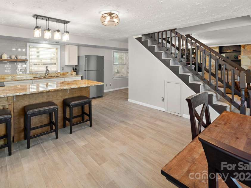 4075 Little River Road, Hendersonville, NC 28739.  MLS# CAR4243668, YatesRealty ID 24087. Stairs lead from the two bedrooms of the 2nd living quarters to fully finished lower level - kitchen & living room with separate entrance. (entire 2nd quarters can be left contiguous to main home)