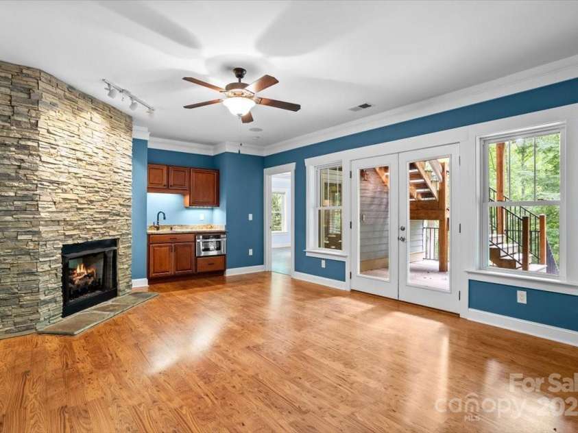 311 Carriage Crest Drive, Hendersonville, NC 28791.  MLS# CAR4263699, YatesRealty ID 24164. Lower level entertainment space, looking at a large deck and a bedroom with an en suite bathroom.