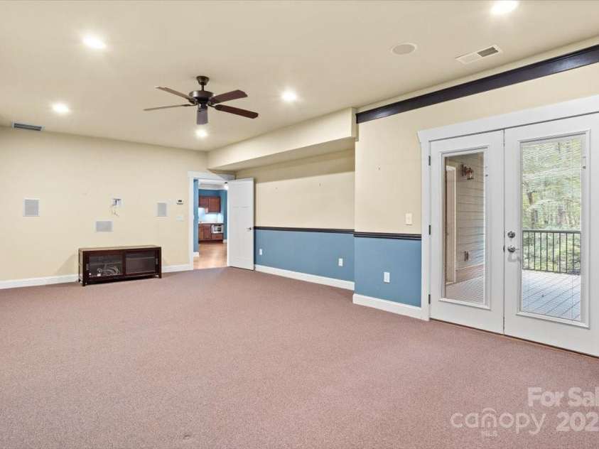 311 Carriage Crest Drive, Hendersonville, NC 28791.  MLS# CAR4263699, YatesRealty ID 24164. Lower level media room with access to a private covered porch.