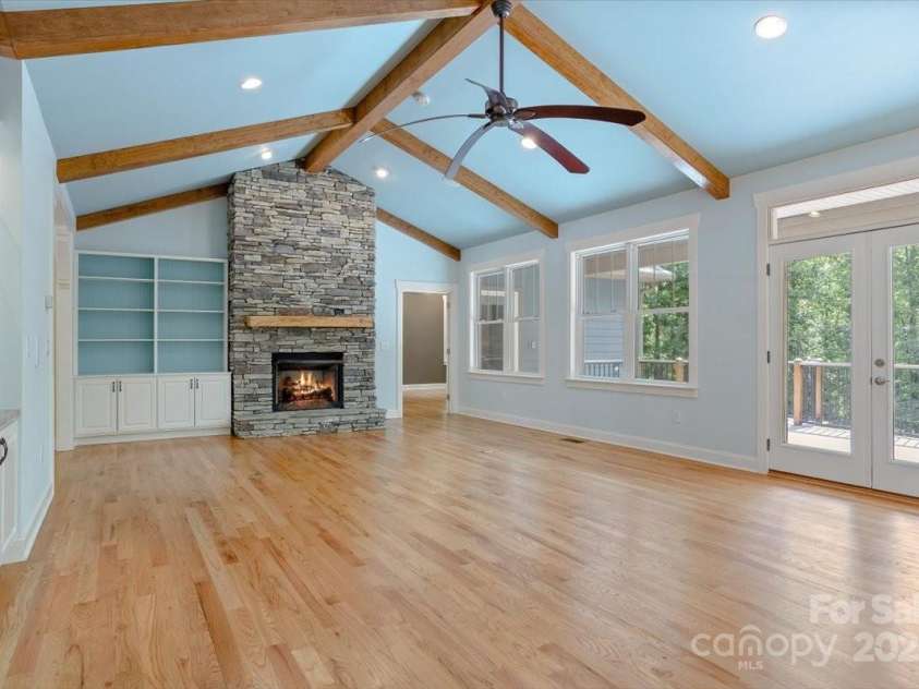 311 Carriage Crest Drive, Hendersonville, NC 28791.  MLS# CAR4263699, YatesRealty ID 24164. Standing between the dining room and the kitchen looking towards the the primary bedroom and fireplace.