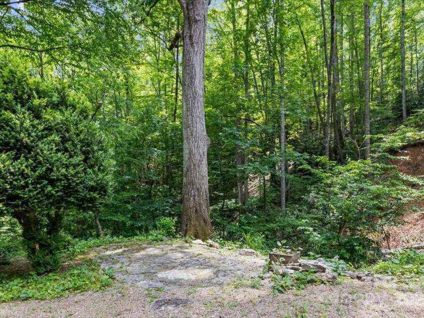 311 Carriage Crest Drive, Hendersonville, NC 28791.  MLS# CAR4263699, YatesRealty ID 24164. Stone pavers for outdoor dining set near the small creek.