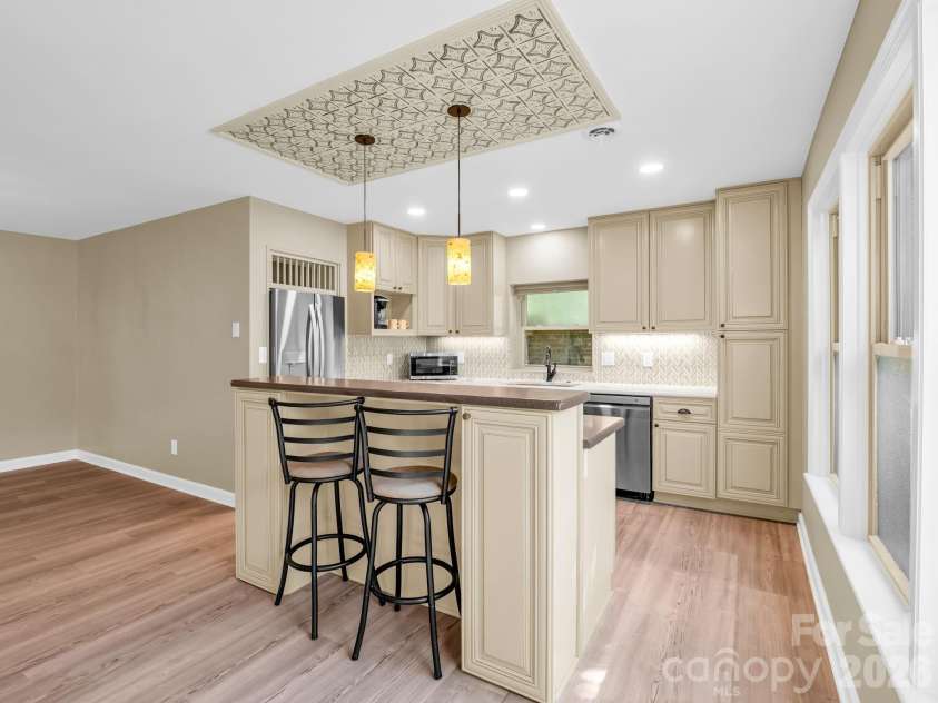 44 Jervey Road, Tryon, NC 28782.  MLS# CAR4381509, YatesRealty ID 24179. The breakfast bar and island with a custom tin design overhead.