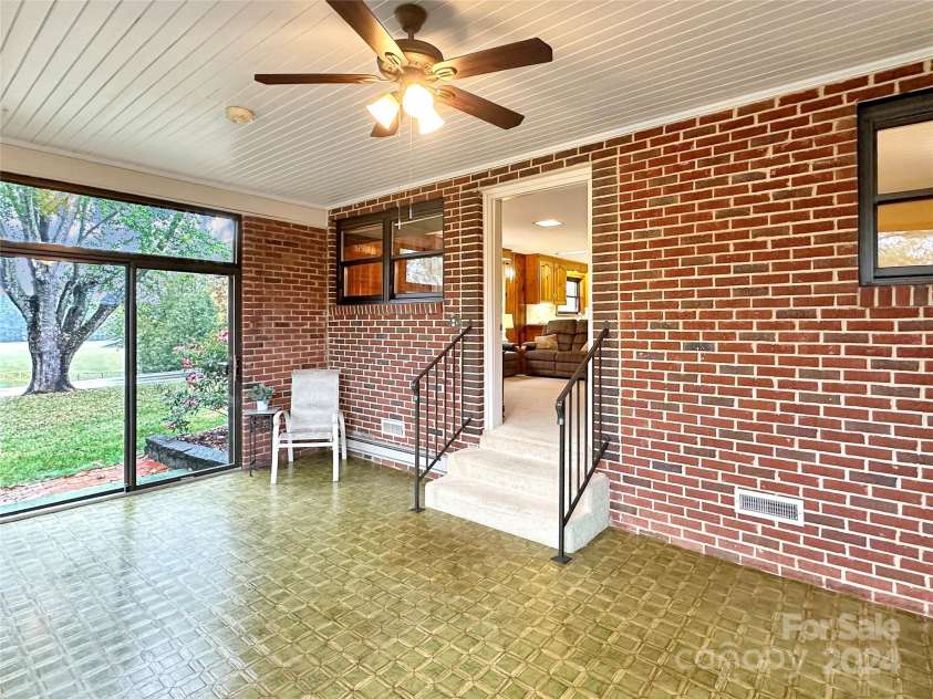 8031 George Hildebran School Road, Connelly Springs, NC 28612.  MLS# CAR4198034, YatesRealty ID 2418. Sunroom w/doors to front yard and door to carport area.  Steps lead into the den.