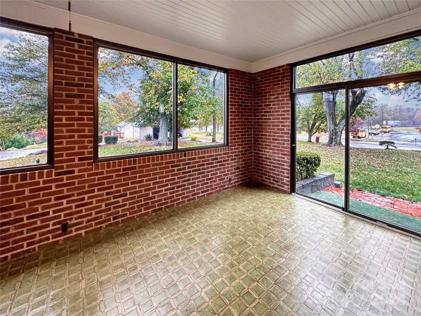 8031 George Hildebran School Road, Connelly Springs, NC 28612.  MLS# CAR4198034, YatesRealty ID 2418. Sunroom w/doors to front yard and door to carport area.  Steps lead into the den.