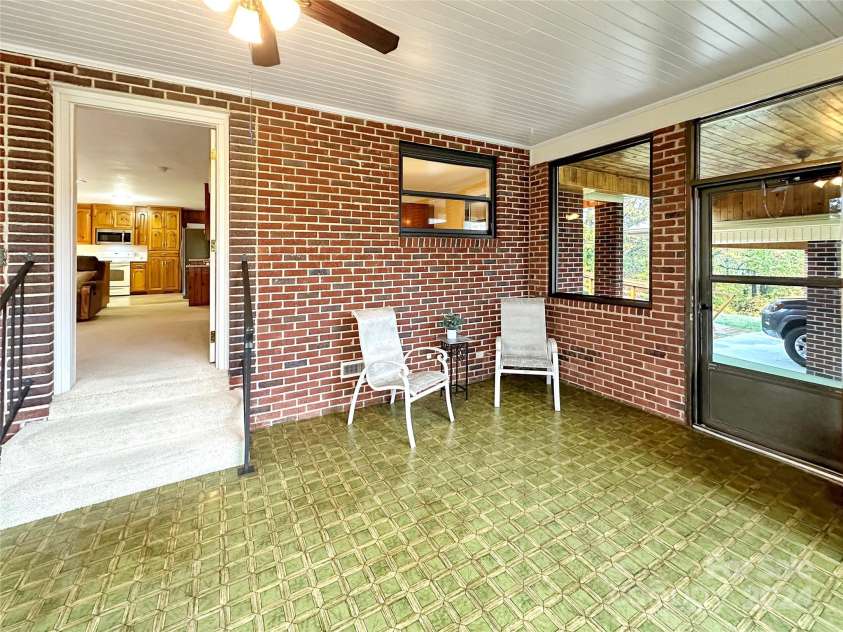 8031 George Hildebran School Road, Connelly Springs, NC 28612.  MLS# CAR4198034, YatesRealty ID 2418. Sunroom w/doors to front yard and door to carport area.  Steps lead into the den.