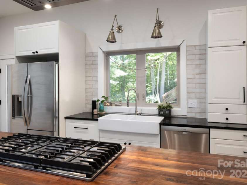 628 Brush Creek Road, Fairview, NC 28730.  MLS# CAR4256769, YatesRealty ID 24181. A kitchen fit for a chef with gas range, ample counter space, farmhouse sink and stainless steel appliances