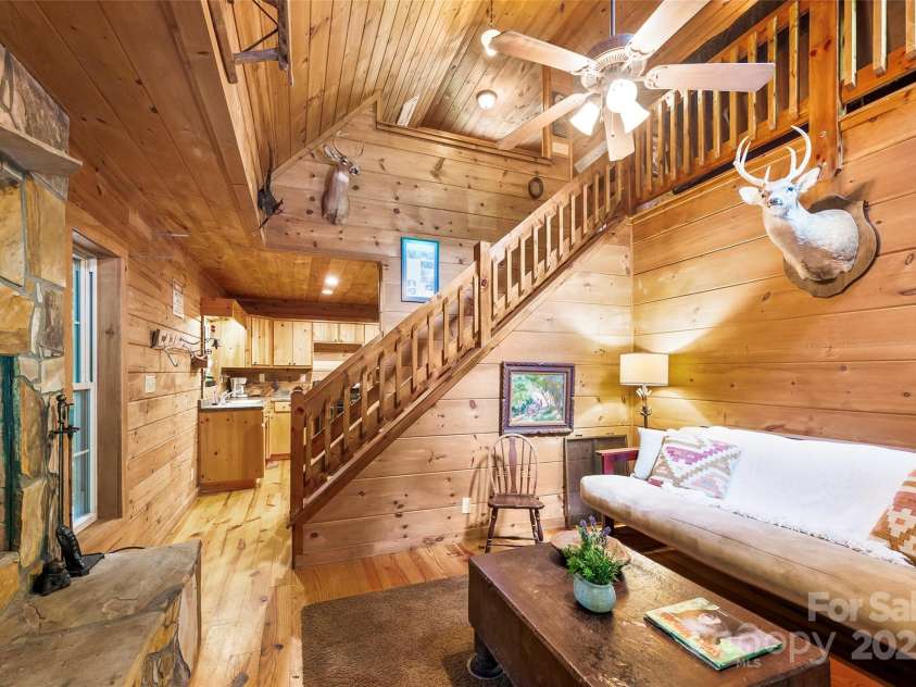 70 Wetherbee Lane, Rosman, NC 28772.  MLS# CAR4277160, YatesRealty ID 24192. Downstairs Living Room with Wood Burning Fireplace