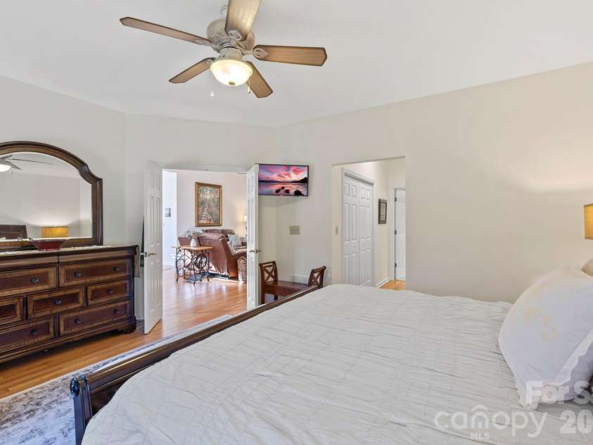 24 Country Meadows Lane, Hendersonville, NC 28792.  MLS# CAR4336584, YatesRealty ID 2420. Additional view of the primary bedroom highlighting generous room size, ceiling fan, and easy access to adjacent living areas