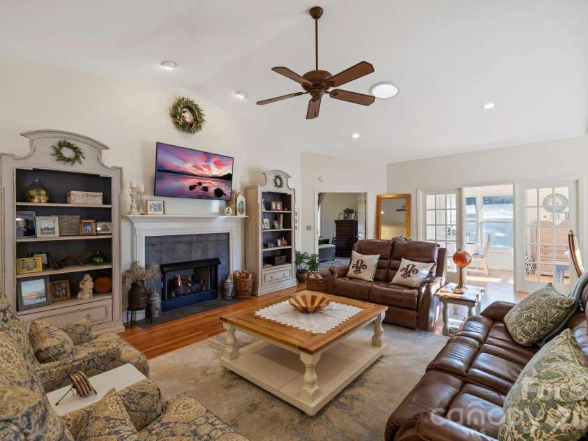 24 Country Meadows Lane, Hendersonville, NC 28792.  MLS# CAR4336584, YatesRealty ID 2420. Bright and spacious living room featuring vaulted ceilings, recessed lighting, hardwood floors, and a cozy fireplace flanked by built-in shelving