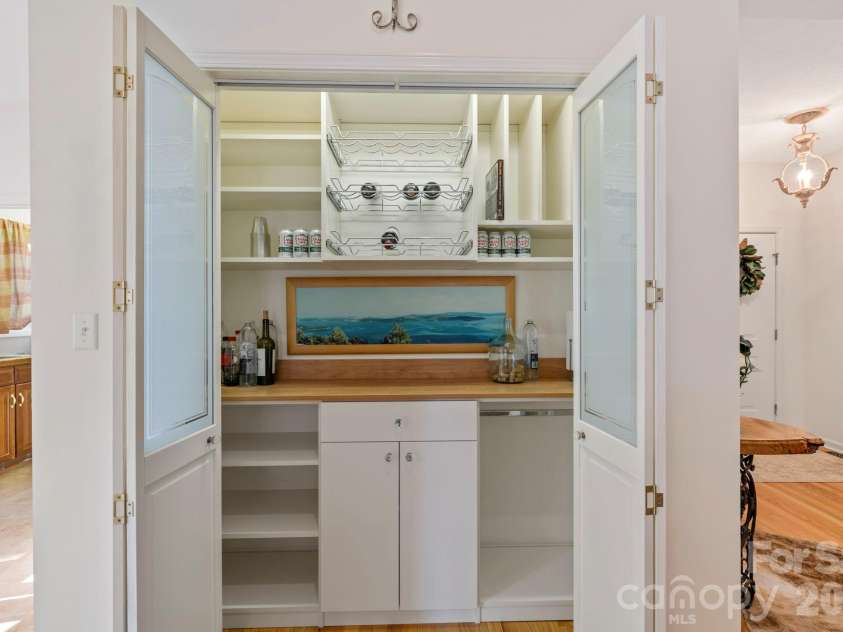 24 Country Meadows Lane, Hendersonville, NC 28792.  MLS# CAR4336584, YatesRealty ID 2420. Built-in pantry and beverage area with shelving, wine storage, and counter space, perfect for entertaining and additional storage.  Could also be converted into closet for 3rd bedroom