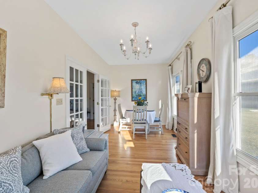 24 Country Meadows Lane, Hendersonville, NC 28792.  MLS# CAR4336584, YatesRealty ID 2420. Cozy yet spacious sitting room featuring neutral finishes, French door access, and abundant natural light from oversized windows