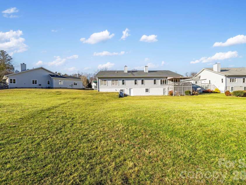 24 Country Meadows Lane, Hendersonville, NC 28792.  MLS# CAR4336584, YatesRealty ID 2420. Open grassy area behind the home providing scenic views and a sense of openness within the community