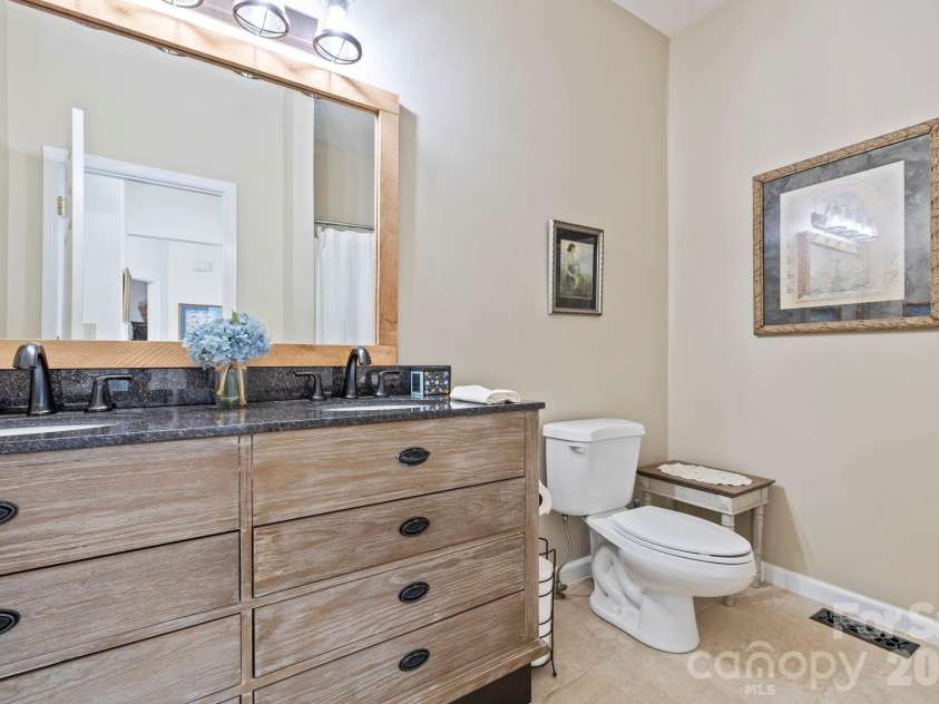 24 Country Meadows Lane, Hendersonville, NC 28792.  MLS# CAR4336584, YatesRealty ID 2420. Updated bathroom with a wide vanity, granite countertop, framed mirror, and neutral finishes