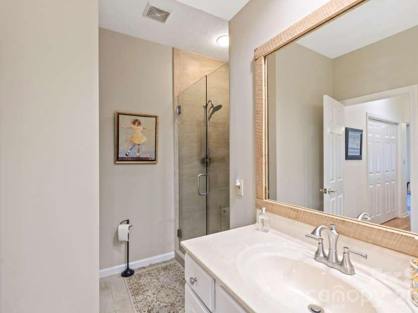 24 Country Meadows Lane, Hendersonville, NC 28792.  MLS# CAR4336584, YatesRealty ID 2420. Walk-in shower with tile surround and glass enclosure, offering a clean and functional design