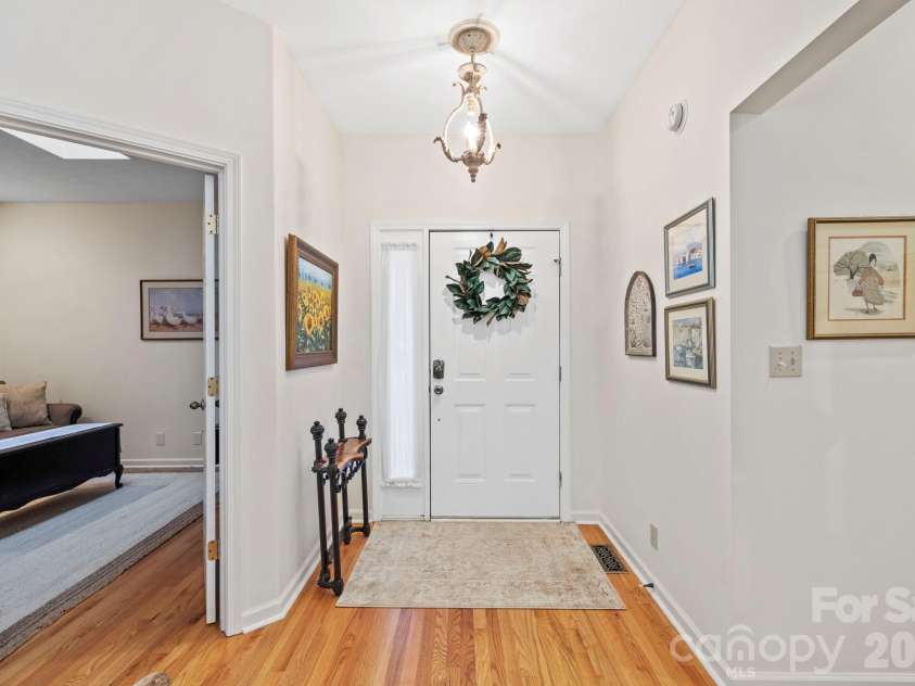 24 Country Meadows Lane, Hendersonville, NC 28792.  MLS# CAR4336584, YatesRealty ID 2420. Welcoming front entry with hardwood flooring, decorative lighting, and a clear line of sight into the home’s living spaces