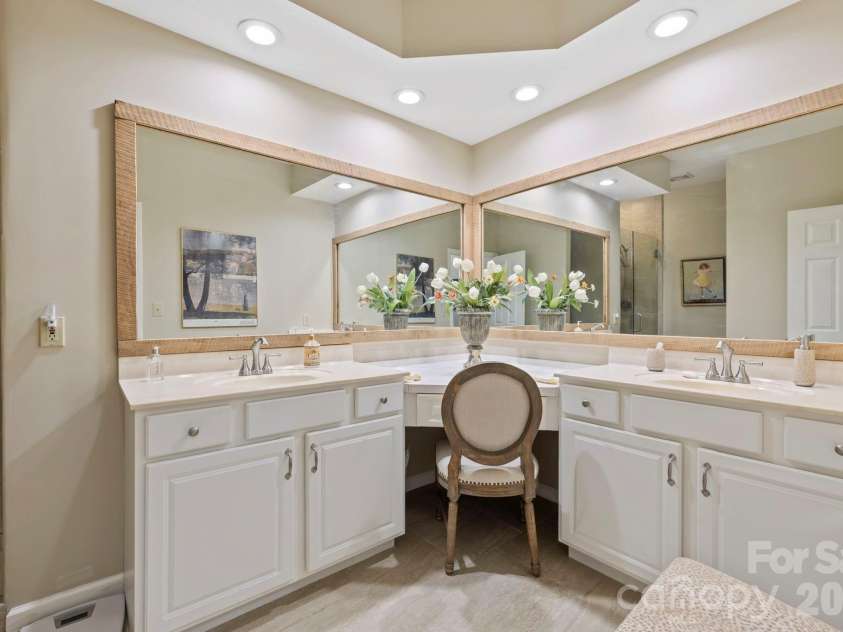 24 Country Meadows Lane, Hendersonville, NC 28792.  MLS# CAR4336584, YatesRealty ID 2420. Well-appointed primary bathroom featuring dual vanities, expansive mirrors, recessed lighting, and ample storage