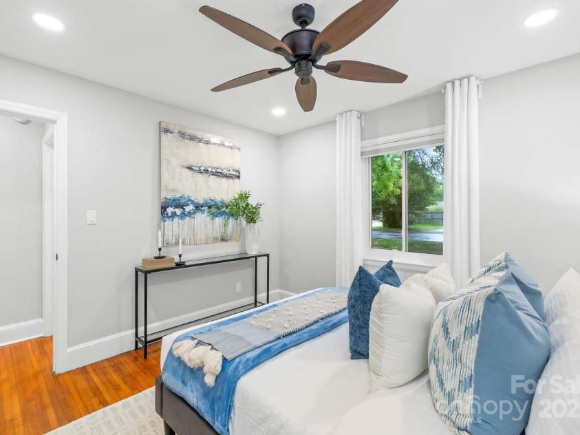 4114 Stacy Boulevard, Charlotte, NC 28209.  MLS# CAR4258425, YatesRealty ID 24208. Featuring original hardwood flooring and a ceiling fan, the secondary bedroom offers a serene space with neutral wall colors and recessed lighting as well.