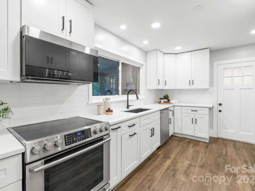4114 Stacy Boulevard, Charlotte, NC 28209.  MLS# CAR4258425, YatesRealty ID 24208. Pristine quartz countertops provide an elegant workspace, enhancing the kitchen's overall appeal.