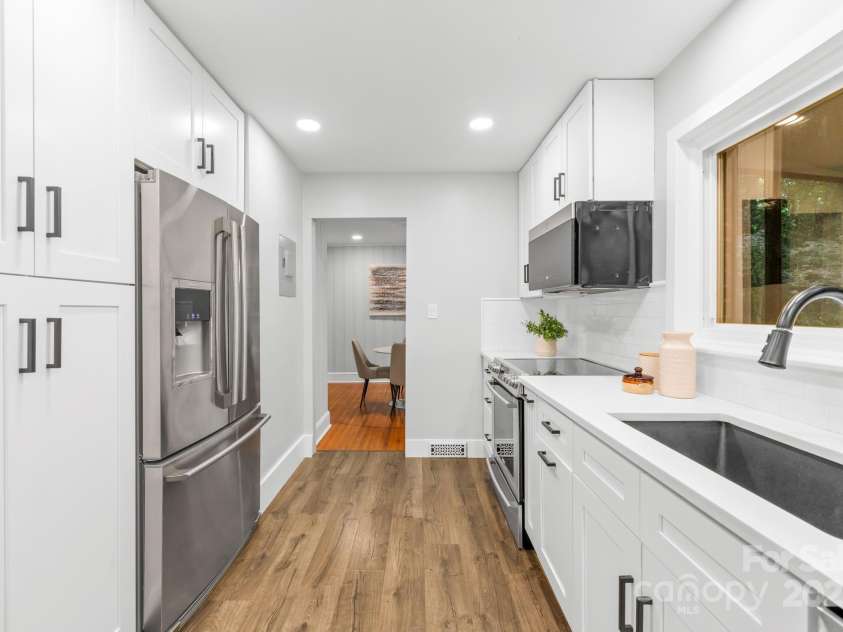 4114 Stacy Boulevard, Charlotte, NC 28209.  MLS# CAR4258425, YatesRealty ID 24208. The blend of white cabinetry and stainless steel appliances creates a bright and inviting culinary space.