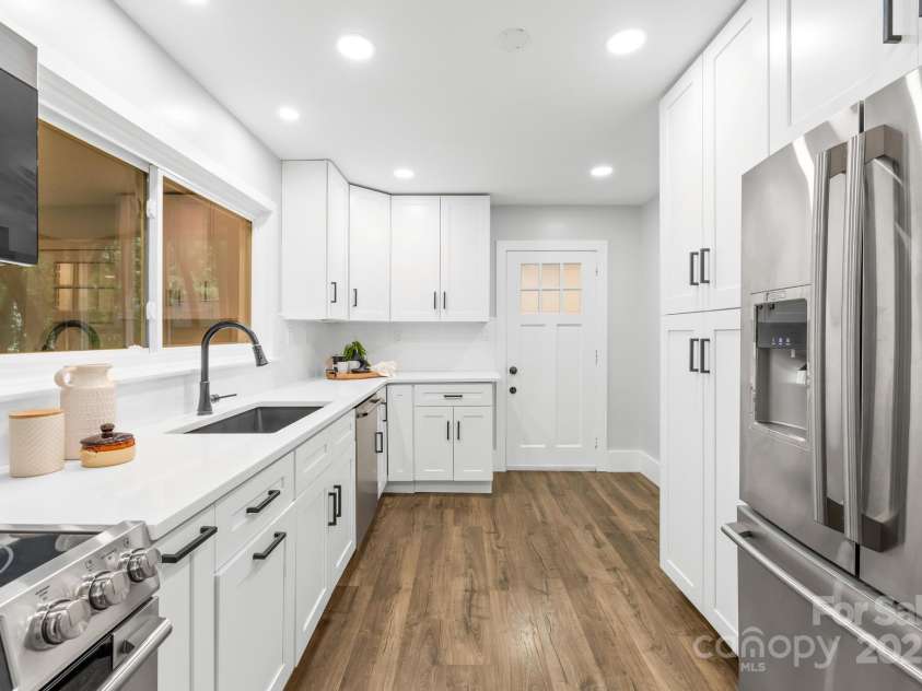 4114 Stacy Boulevard, Charlotte, NC 28209.  MLS# CAR4258425, YatesRealty ID 24208. The kitchen boasts an abundance of soft-close white cabinets, offering ample storage and a clean, contemporary aesthetic.