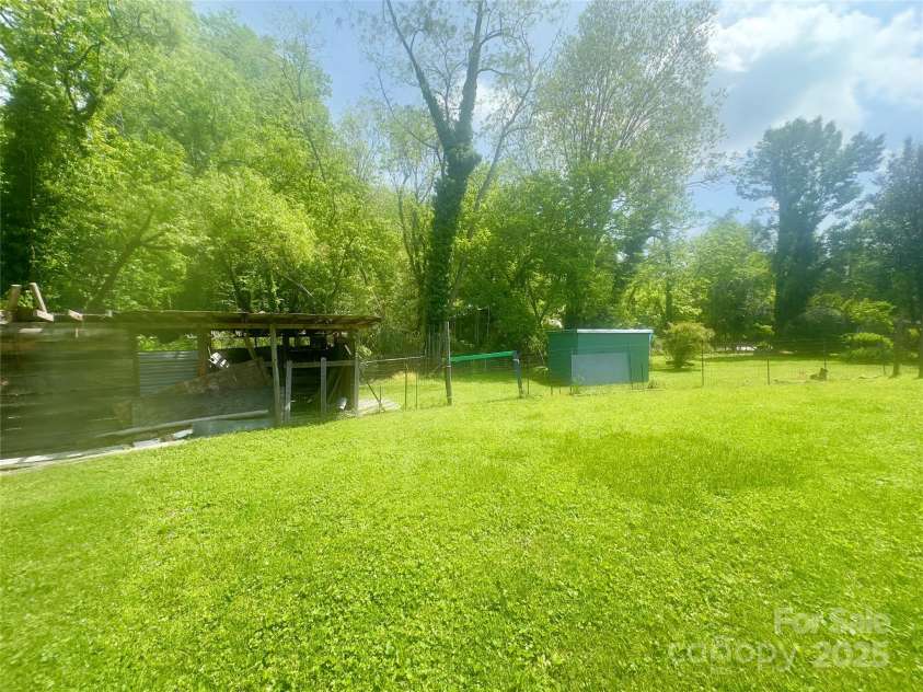 175 Spring Street, Marion, NC 28752.  MLS# CAR4253514, YatesRealty ID 24210. Charming side yard adjoining the creek, just waiting to be transformed into a flourishing garden oasis