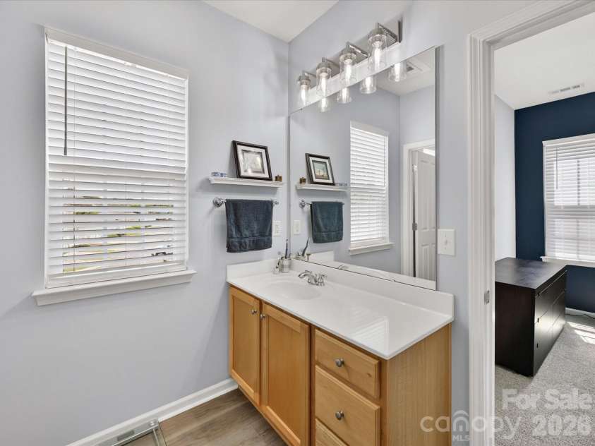 15224 Waterfront Drive, Huntersville, NC 28078.  MLS# CAR4374936, YatesRealty ID 24231. Bright and functional primary bathroom featuring a spacious vanity with ample storage, large mirror, and a tub/shower combination for everyday convenience.